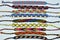 Multi-colored woven friendship bracelets handmade of embroidery bright thread with knots on light gray background