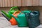 Multi coloured watering cans in a garden