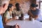 Multi-Cultural Business Team Taking Coffee Break In Kitchen Area Of Modern Open Plan Office Together