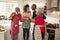 Multi-ethnic adult family embrace and make a toast with champagne to celebrate on Christmas Day while preparing dinner together in