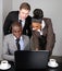 Multi-ethnic business team working on laptop