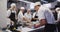 Multi-ethnic chefs in a restaurant kitchen standing at a counter top and preparing food