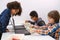 Multi ethnic children at technology lesson coding robot on tablet