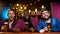 Multi-ethnic friends smiling watching comedy show on big screen in beer pub, fun