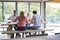 Multi ethnic group of four young adult friends eating at a casual dinner party in a modern dining room