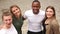 Multi-ethnic group. Four young students hug and laugh. Top view, outdoor portrait, multiracial group of people