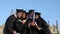 Multi ethnic group of graduated students taking selfie.