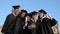 Multi ethnic group of graduated students taking selfie.