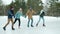 Multi-ethnic group of men and women Asian and Caucasian ice-skating in park