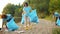 Multi-ethnic group of students collecting garbage from beautiful lake beach