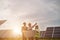 Multi ethnic people in hardhats standing among solar plant