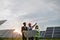 Multi ethnic people in hardhats standing among solar plant