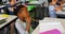 Multi-ethnic school kids studying at desk in classroom at school 4k