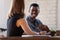 Multi-ethnic smiling teammates working together sitting at desk