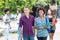 Multi ethnic student couple walking and talking in city