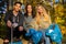 Multi-ethnic volunteers in environmental protection team sitting with garbage bags