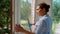 Multi-ethnic woman, maid, housewife, homemaker spraying detergent and cleaning windows in the veranda. Household Chores