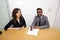 Multi-ethnic work colleagues signing paperwork on a table