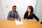 Multi-ethnic work colleagues signing paperwork on a table