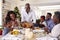 Multi-Generation Family Celebrating Christmas At Home With Grandfather Serving Turkey