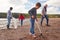 Multi-Generation Family Collecting Litter On Winter Beach Clean Up