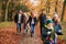 Multi-Generation Family Enjoying Walk Along Autumn Woodland Path Together