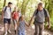 Multi Generation Family Enjoying Walk Along Woodland Path Together