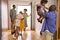 Multi-Generation Family With Grandparents Greeting Grandchildren in Hallway At Home