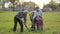 Multi generation family planting tree outdoor.