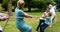 Multi-generation family pulling a rope in tug of war