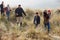 Multi Generation Family In Sand Dunes On Winter Beach