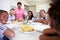 Multi-Generation Family Sitting Around Table Eating Meal