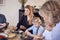 Multi-Generation Family Sitting Around Table At Home In Pyjamas Enjoying Brunch Together