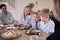 Multi-Generation Family Sitting Around Table At Home In Pyjamas Enjoying Brunch Together