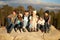 Multi generation family sitting on rocky outcrop near a forest