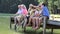 Multi-Generation Family Sitting On Wooden Jetty By Lake