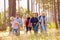 Multi-generation family walking in countryside, kids running