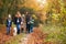 Multi-Generation Family Walking With Pet Golden Retriever Dog Along Autumn Woodland Path