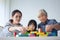 Multi-generation Female members of a family play wooden cubes co