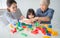 Multi-generation Female members of a family play wooden cubes colour Geometric ladder together with their grandmother