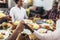 Multi-generational African-American family saying grace at dinner table and holding hands