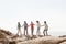 Multi-generational family holding hands on rocks by the sea