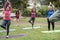 Multi generational people doing yoga class keeping at city park - Focus on senior african woman face