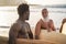 Multi generational surfer men having fun on the beach - Focus on african man