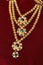 Multi layered artificial golden rani haar jewelry on a red background