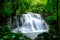 Multi-layered water fall with clouded and foggy like pattern in green forest with soft light