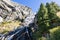 Multi-level alpine Lillaz waterfall Cascate di Lillaz washes granite karst rapids of rock covered with grass and evergreen trees