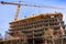 Multi-level concrete building under construction with tower crane; new residential development in the heart of Silicon Valley, San