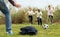 Multi nationalities teenagers play football through green lawn in summer in park