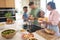 Multi-Racial Family Preparing Meal In Kitchen At Home Together